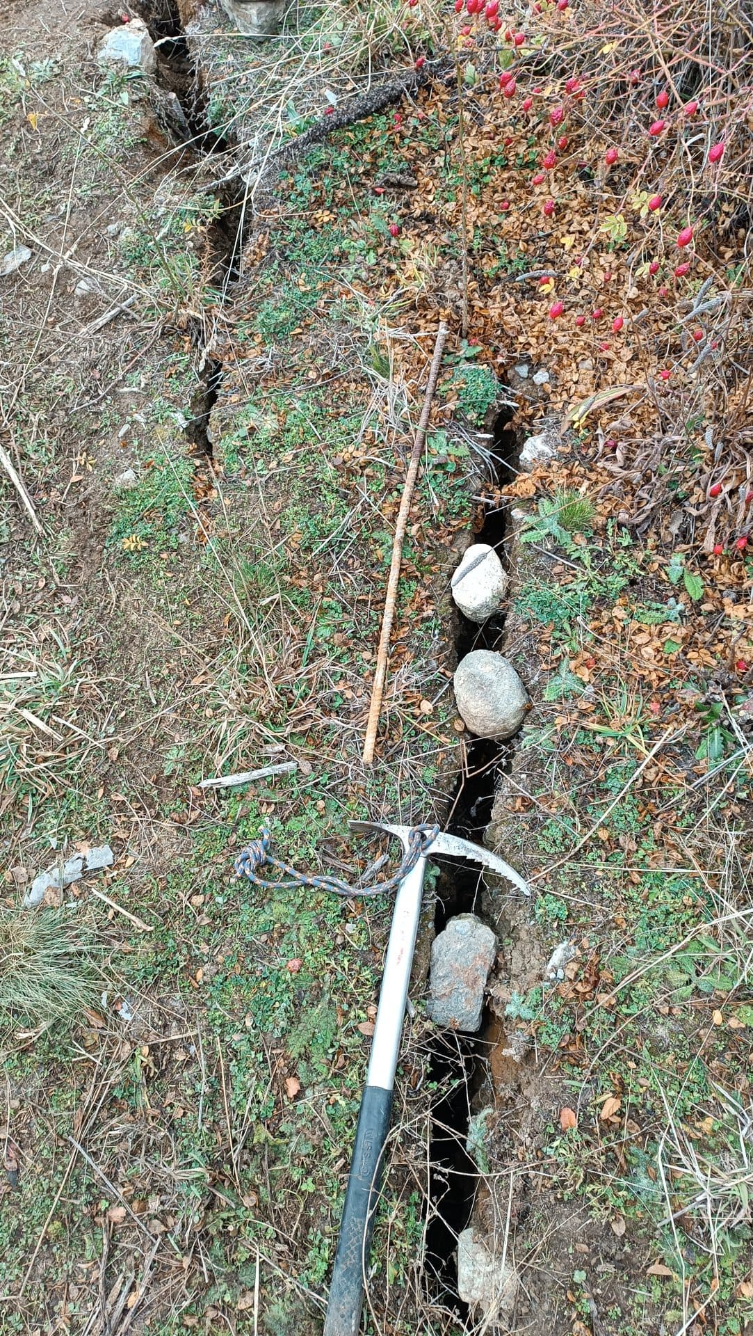 Grieta de tracción en una ladera, con un piolet usado como escala de referencia.